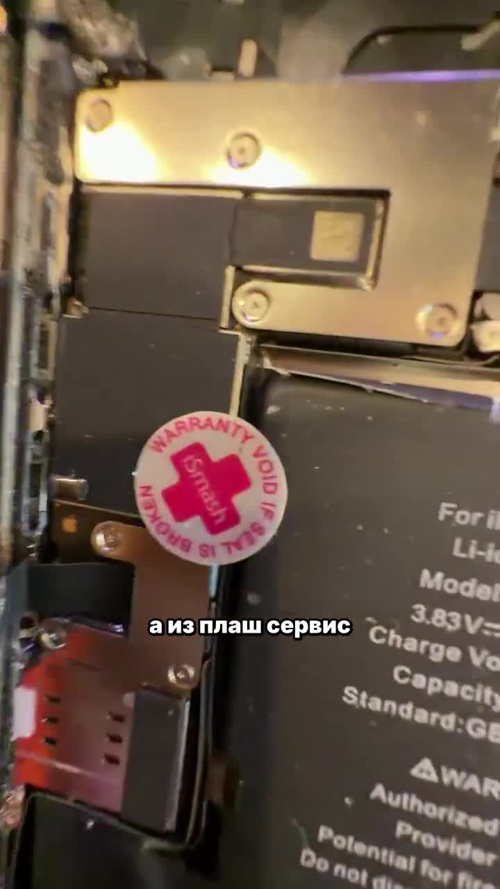 Вскрытый iPhone 12 после залития: разбитая задняя крышка, мятый аккумулятор и остатки проклейки влагозащиты на столе мастера сервиса «Ябука»
